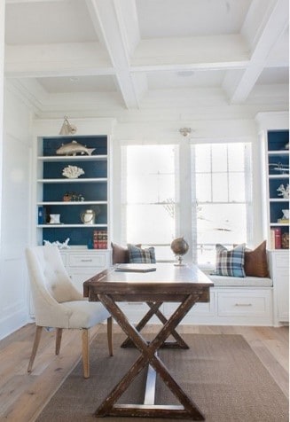 white and teal coastal style home office with white desk chair and wooden desk