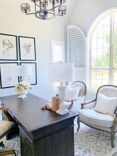 french country office with vintage chairs and arched window with white arched blinds