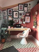 pink and blue funky office with wall art, greenery and patterned carpeting 